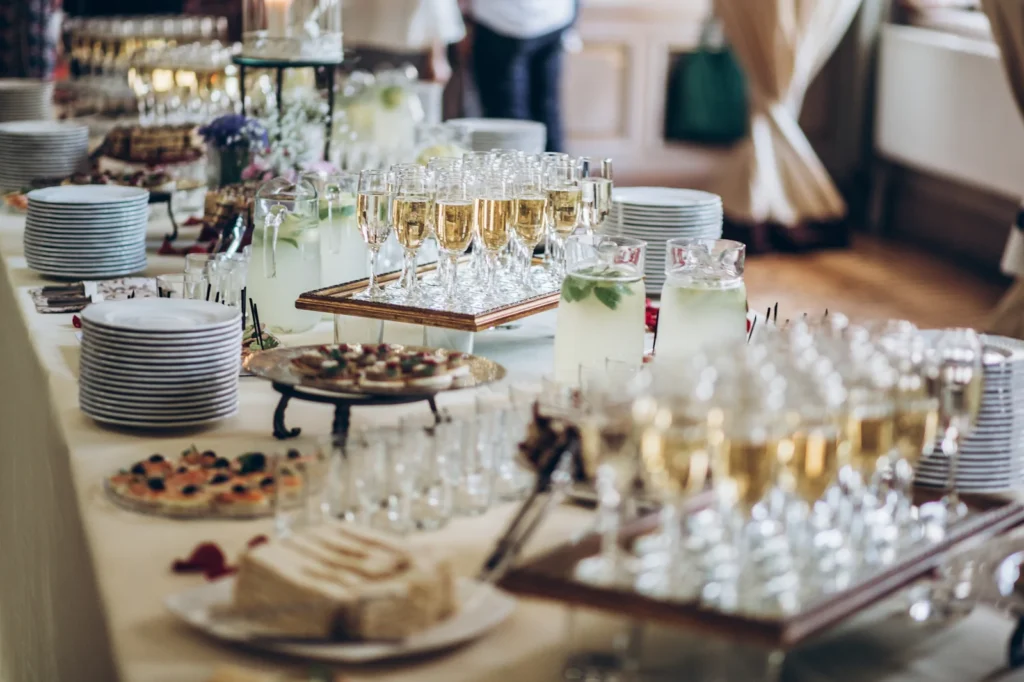 a full catered spread of multiple appetizer options, stacks of fresh plates, and rows of ready-to-enjoy flutes of champagne