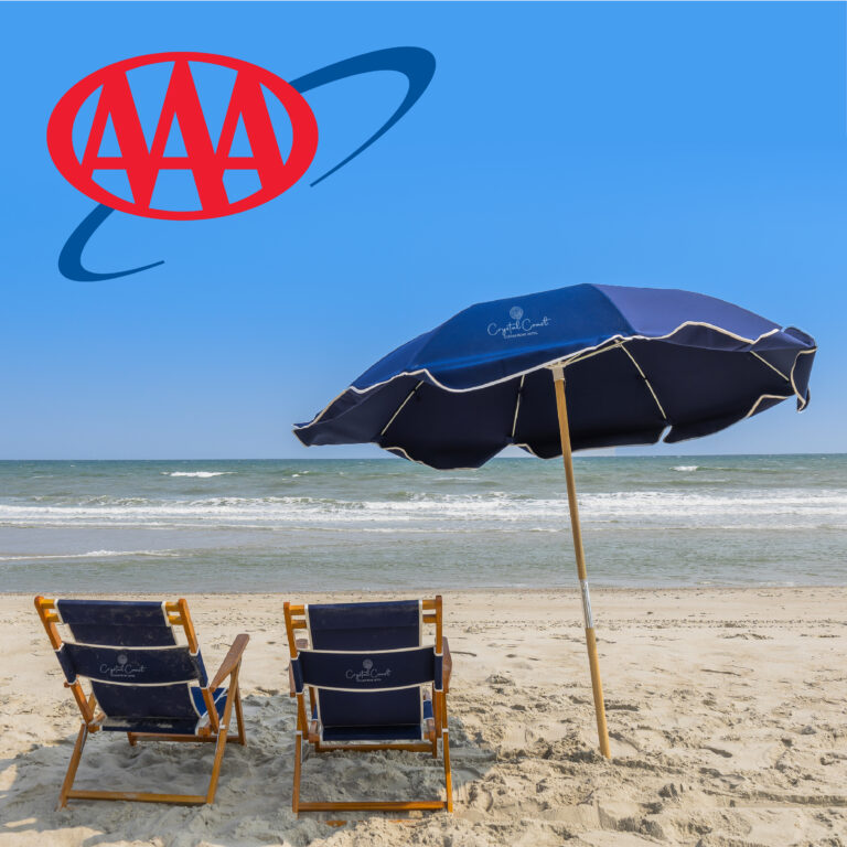 two navy blue beach chairs and an umbrella sit planted on the beach facing the ocean. in the foreground, there is red text that reads "AAA"