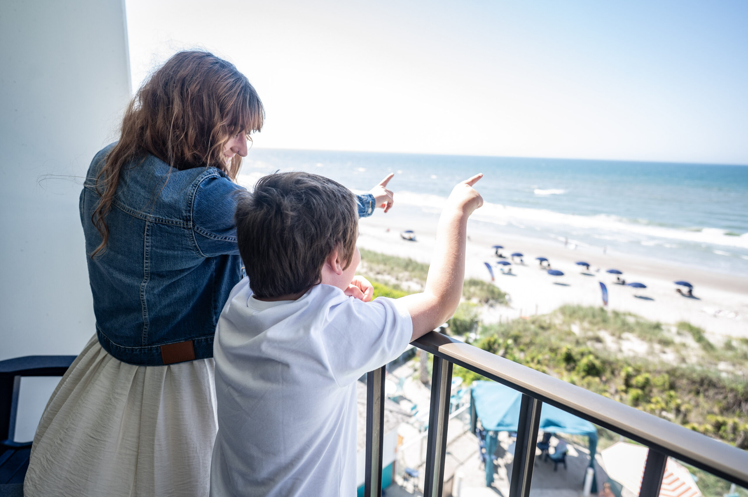 Mom and son on balcony at Crystal Coast Oceanfront Hotel