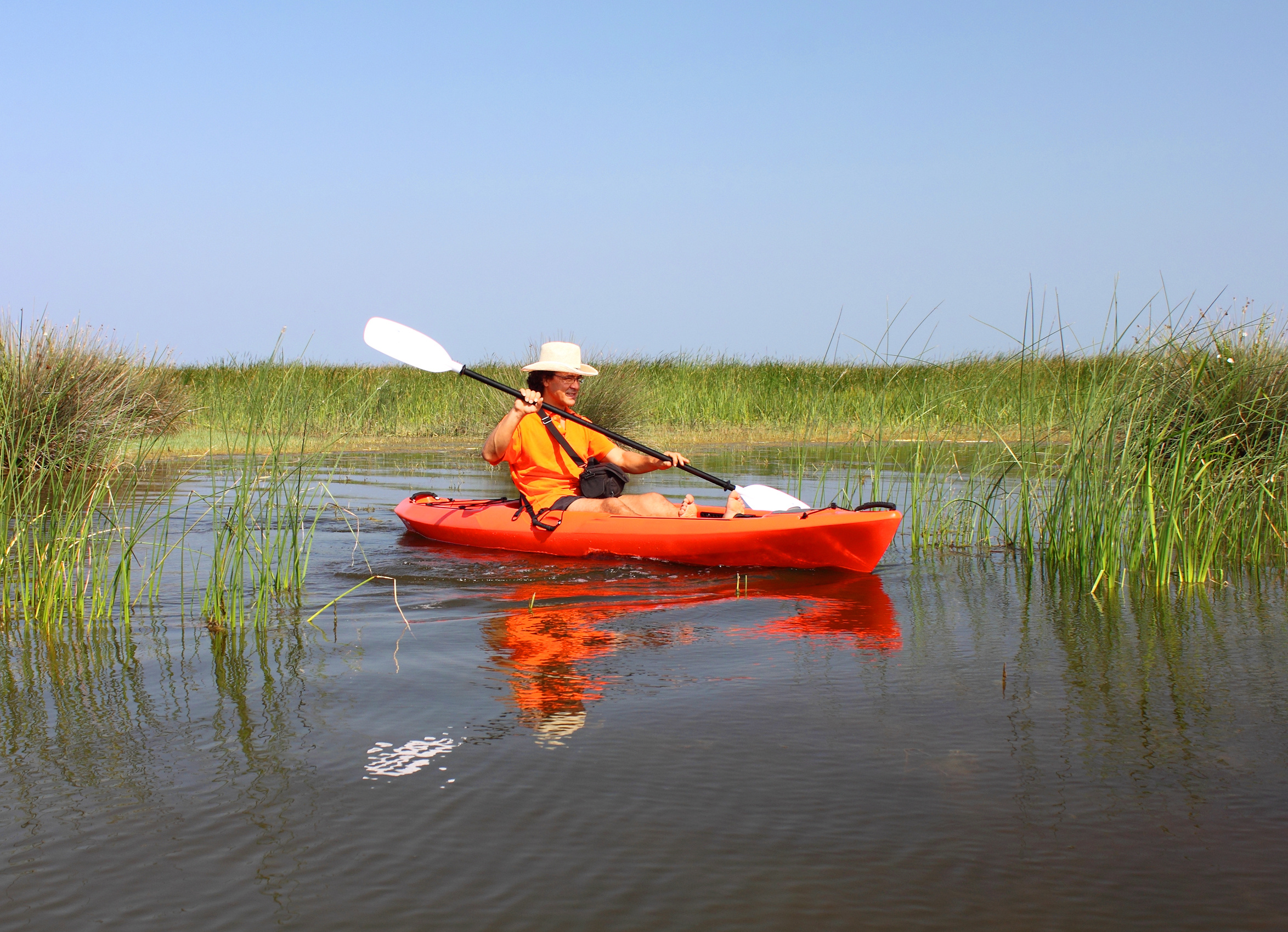 Man kayaking through the marsh